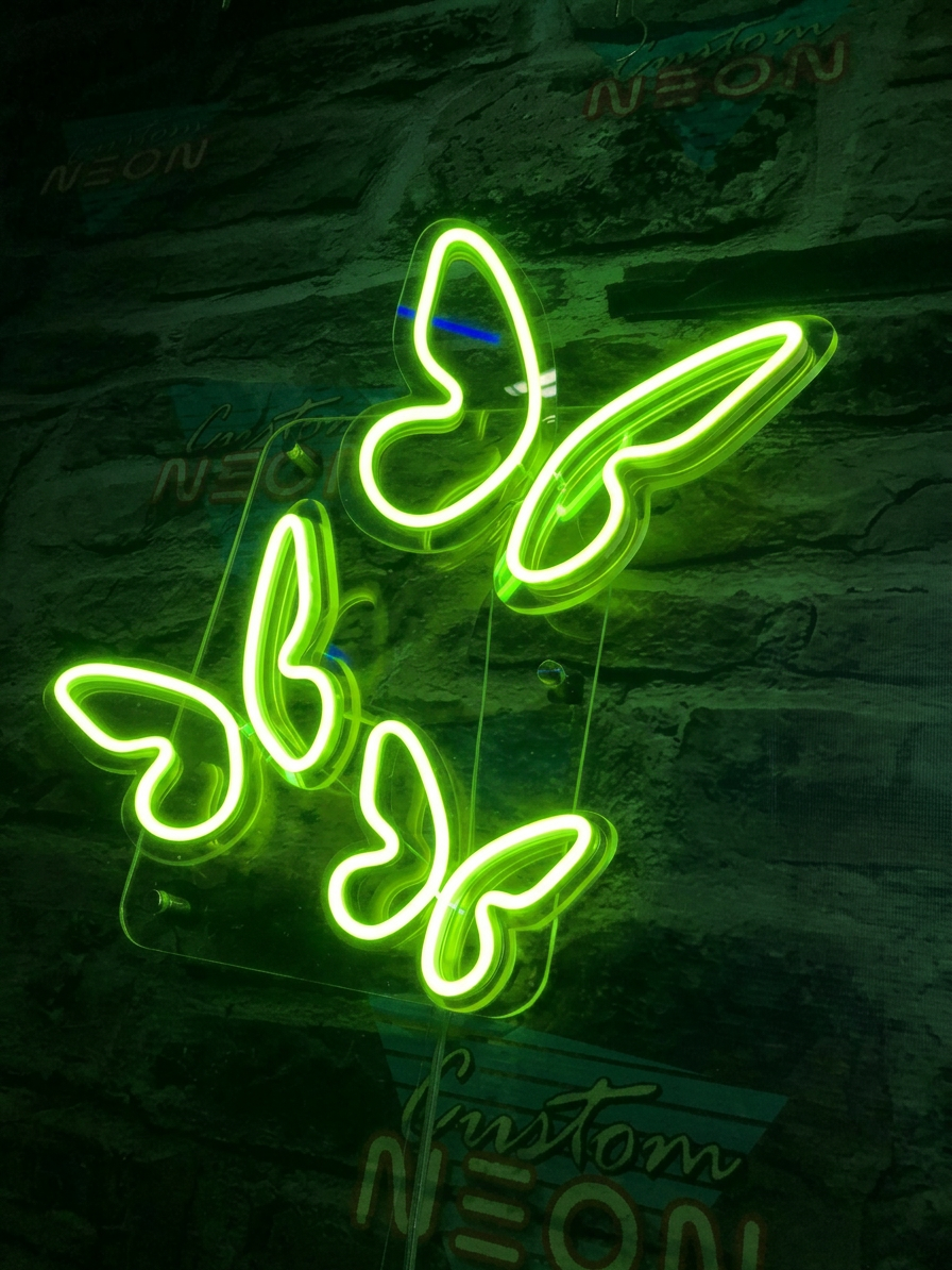 Neon green butterflies on brick wall